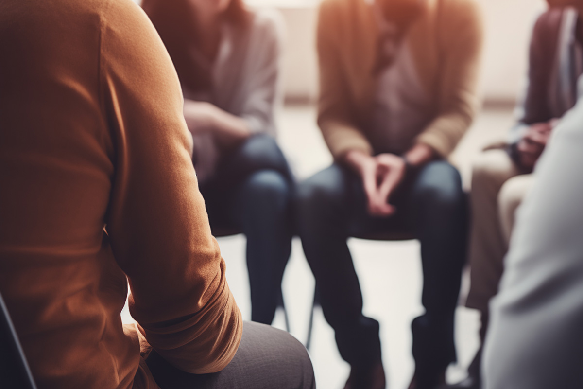 Group of people talking together in a group therapy session.