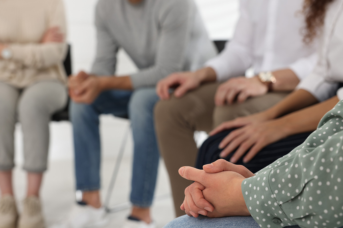 Group of people talking together in a group therapy session.