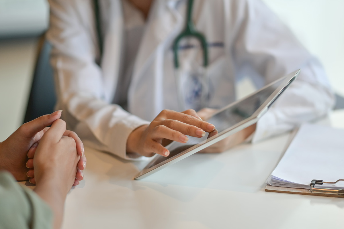 Shot of a doctor showing a patient some information on a digital tablet.