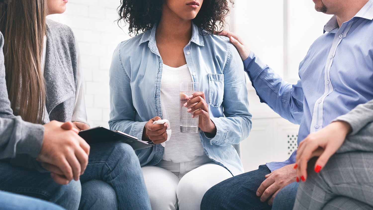 A group therapy session of people talking about their addiction and treatment.