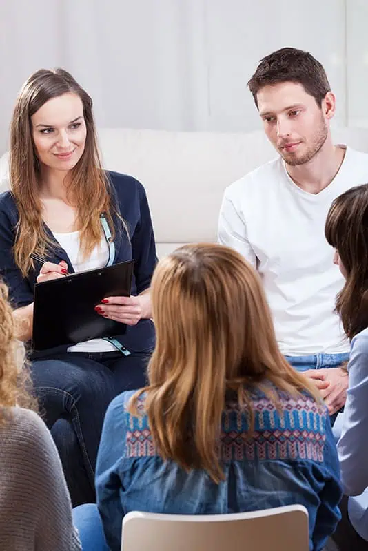 People participate in group therapy for addiction treatment.