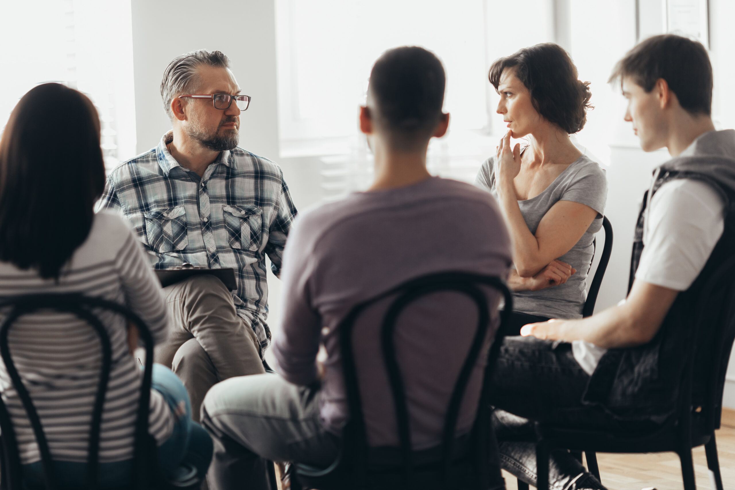 Group of people talking in a process group topics for addiction.
